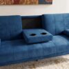 Stylish blue velvet sofa with built-in cup holders and black backrest.