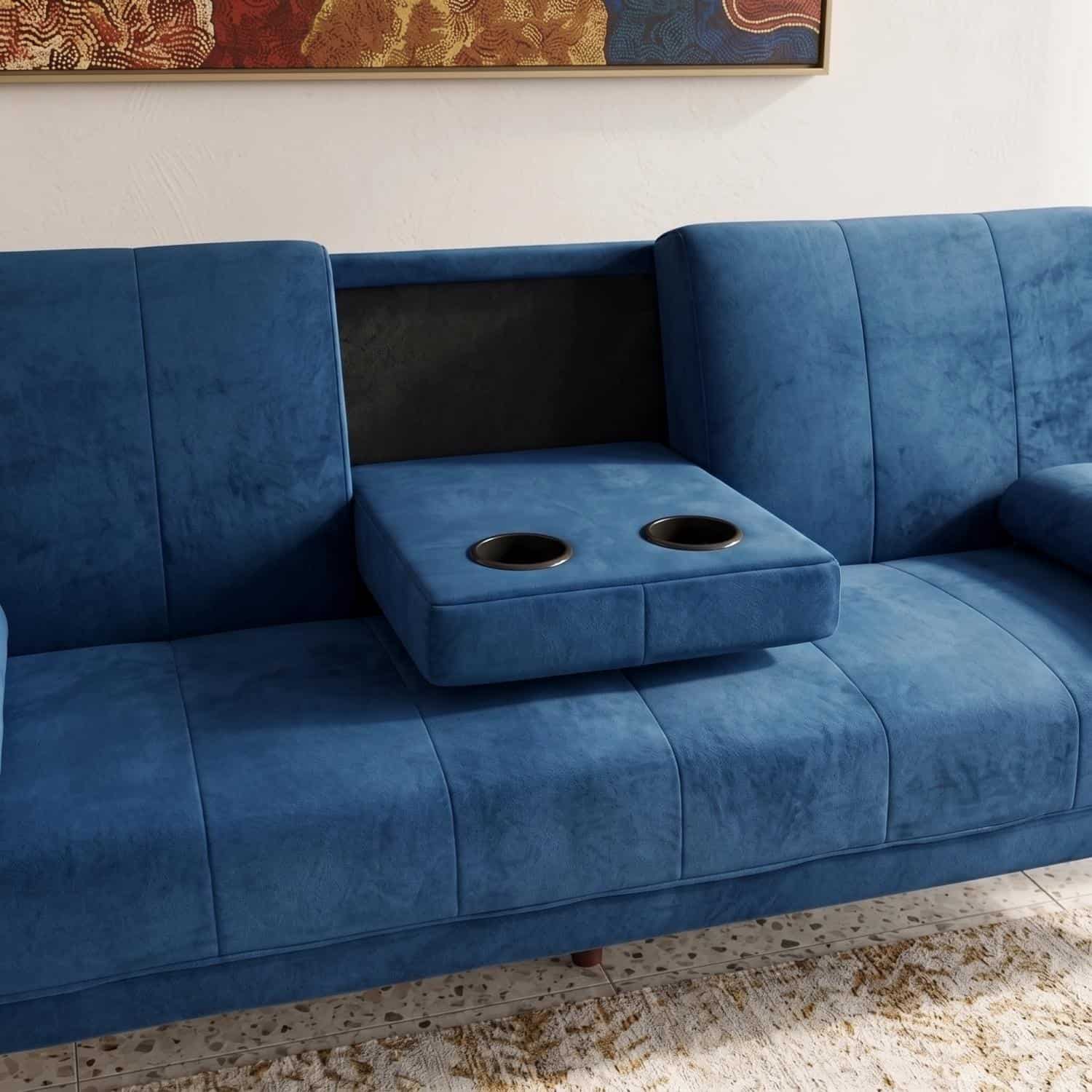 Stylish blue velvet sofa with built-in cup holders and black backrest.
