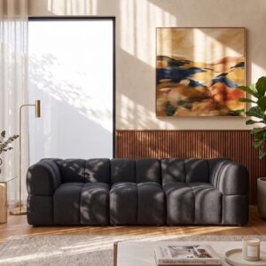 Modern black sofa in a stylish living room with artwork and plants.