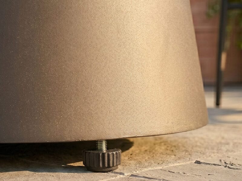 Close-up of a beige outdoor table leg on a tiled surface.