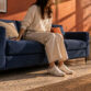 Elegant navy blue sofa in a contemporary living room with natural sunlight.
